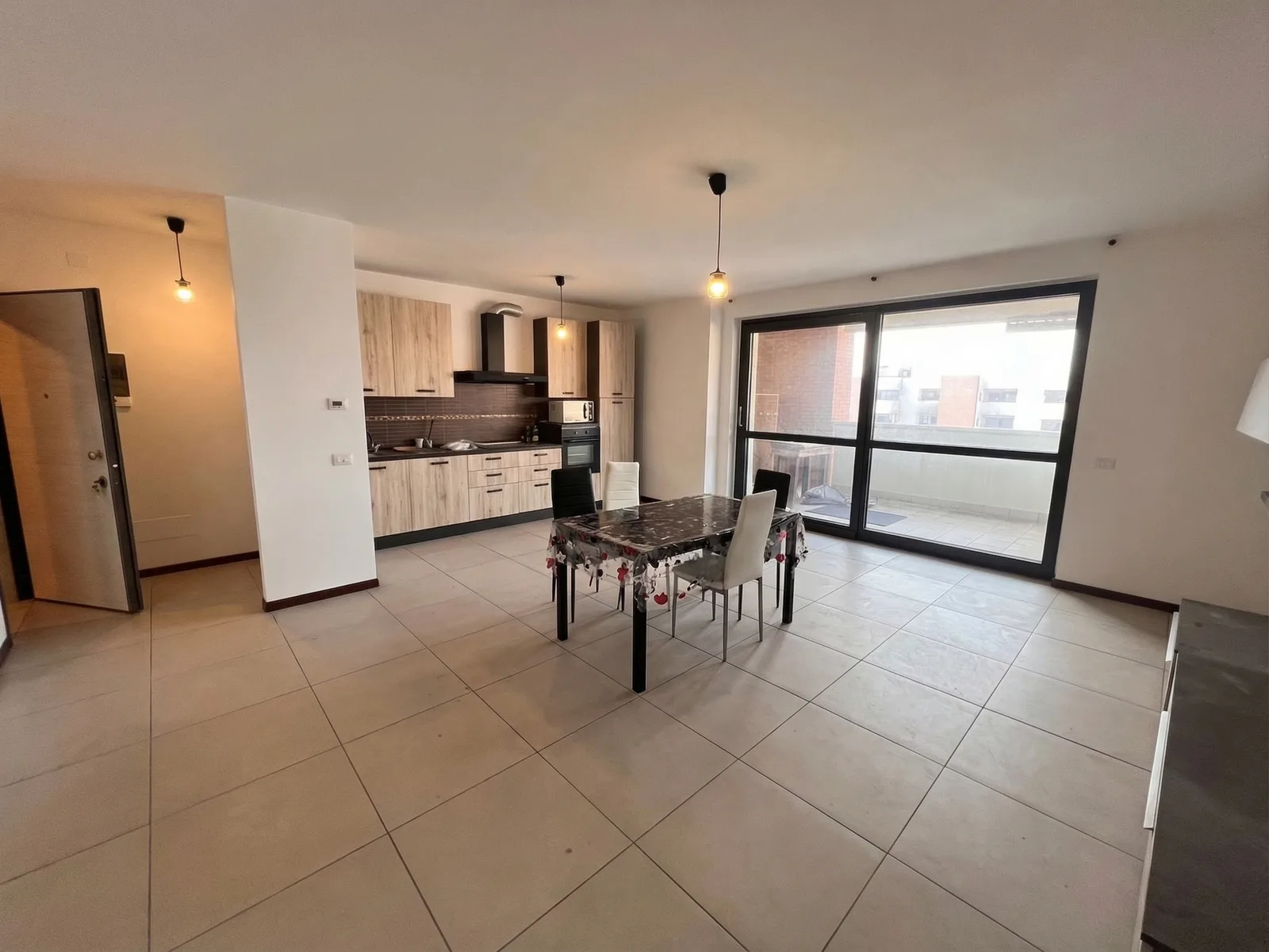 Soggiorno con cucina a vista e tavolo da pranzo, la foto di partenza usata per tutti gli stili